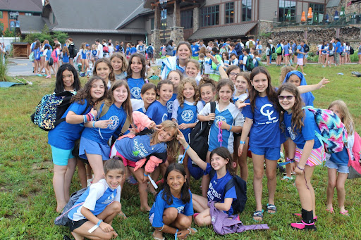 Girls with blue shirts smiling.